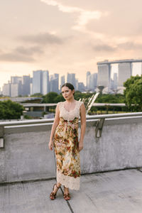 Portrait of smiling young woman standing against wall