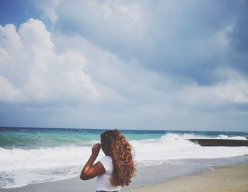 Woman at beach against sky