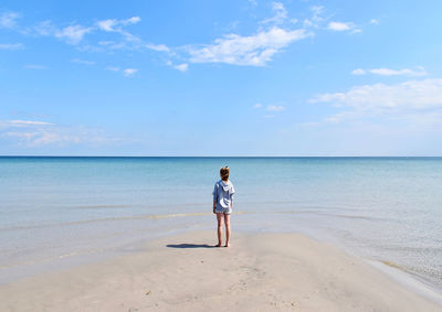 Full length of man standing on beach against sky