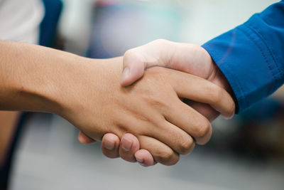 Cropped image of male friends shaking hands