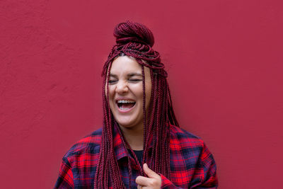 Portrait of young woman standing against yellow wall