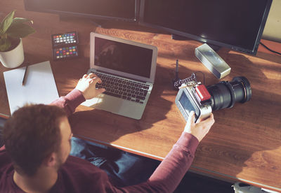 High angle view of young man using laptop on table