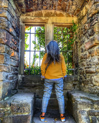 Rear view of woman standing in old building