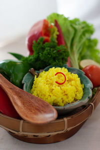 Close-up of nasi kuning in basket on table, indonesian traditional turmeric rice dish