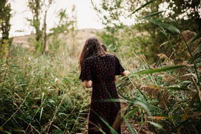 Rear view of woman walking in forest