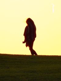Full length of silhouette woman on field against clear sky