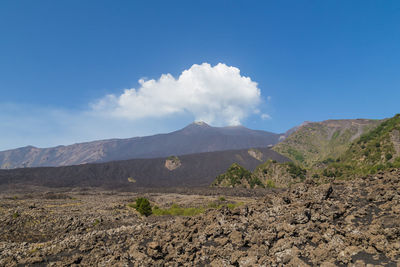 Scenic landscape around active mt. etna volcano. steam clouds rising up from the crater. 