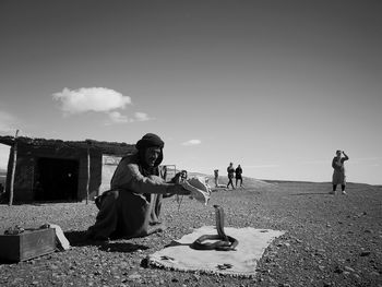 People sitting on beach against sky