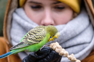 Close-up portrait of a young man holding bird