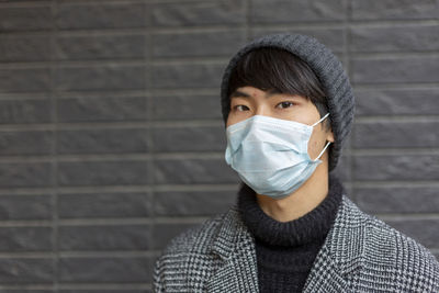 Portrait of man wearing mask against wall