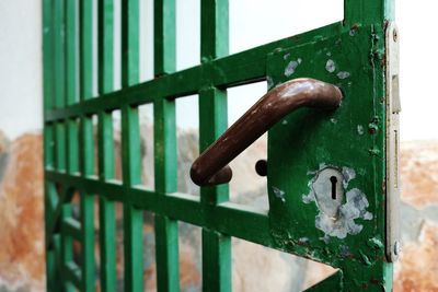 Close-up of rusty handle on metal gate