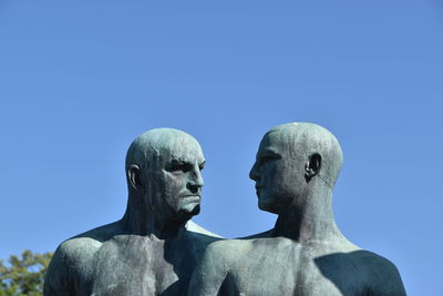 Low angle view of statue against clear blue sky