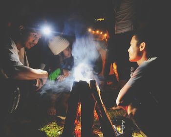 People enjoying campfire at night