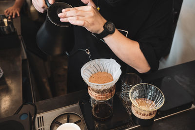 Midsection of man having coffee at cafe