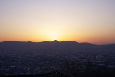 Silhouette cityscape against sky during sunset