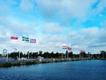 View of flags on lake against sky