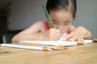 Cute girl drawing in book