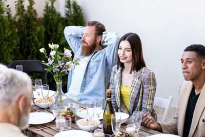 Portrait of smiling friends sitting on table