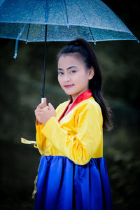 Portrait of young woman holding umbrella