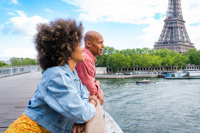 Side view of woman sitting on boat in city