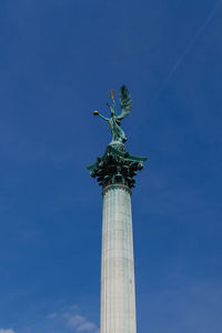 Low angle view of statue against blue sky