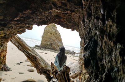 Rock formations on beach against sky