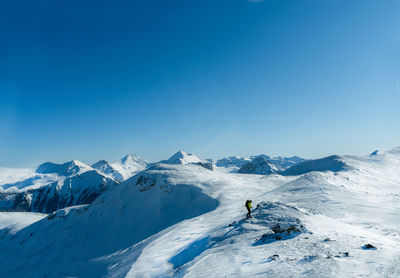 Scenic view of snowcapped mountains against blue sky