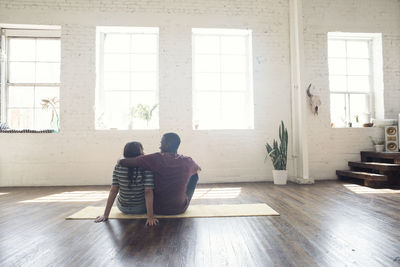Rear view of couple sitting on floor