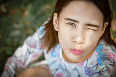 Close-up portrait of young woman puckering lips