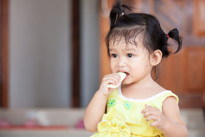 Close-up of cute baby girl eating fruit