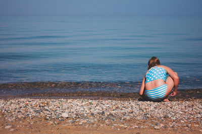 Rear view of man sitting on beach