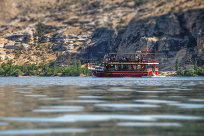 Boat sailing on river by mountain