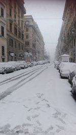 Snow covered city against sky