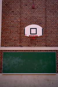 Close-up of basketball hoop against brick wall