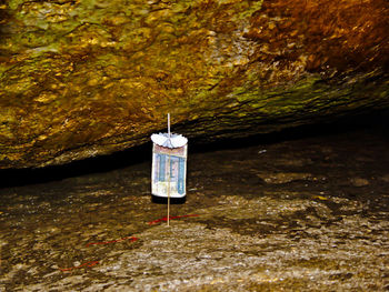 Close-up of telephone pole on rock in river