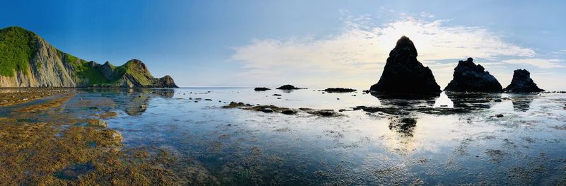 Panoramic view of rock formation on beach against sky