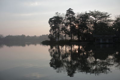 Scenic view of lake by trees against sky