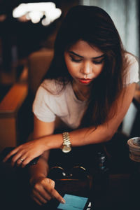 Young woman using mobile phone at cafe