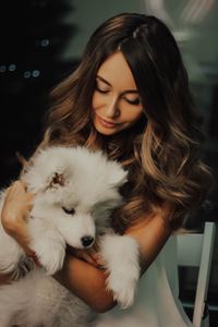 Woman holding dog at home