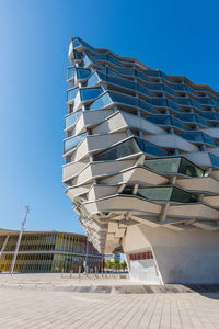 Low angle view of modern building against clear blue sky