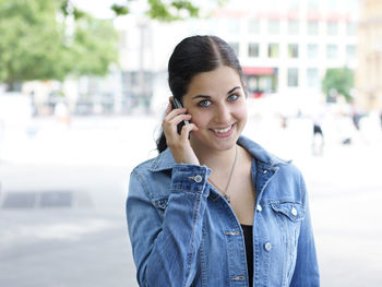 Portrait of smiling young woman talking on phone