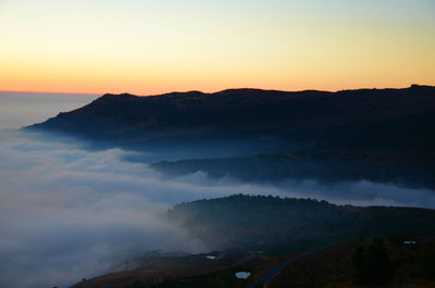 Scenic view of silhouette mountains against sky at sunset