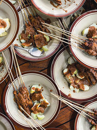 Flat lay view of sate with peanut sauce on table