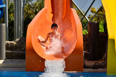 Boy splashing in swimming pool