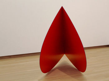 Close-up of red umbrella on table against wall