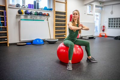 Full length of woman exercising with toy blocks on table