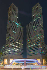 Low angle view of illuminated buildings against sky at night