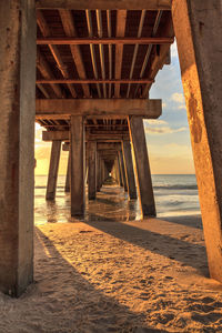 Bridge over sea against sky during sunset