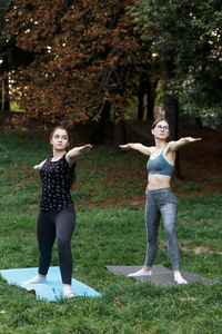 The relaxed girls is doing yoga in the park on carpet