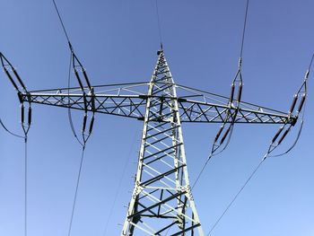 Low angle view of electricity pylon against clear sky